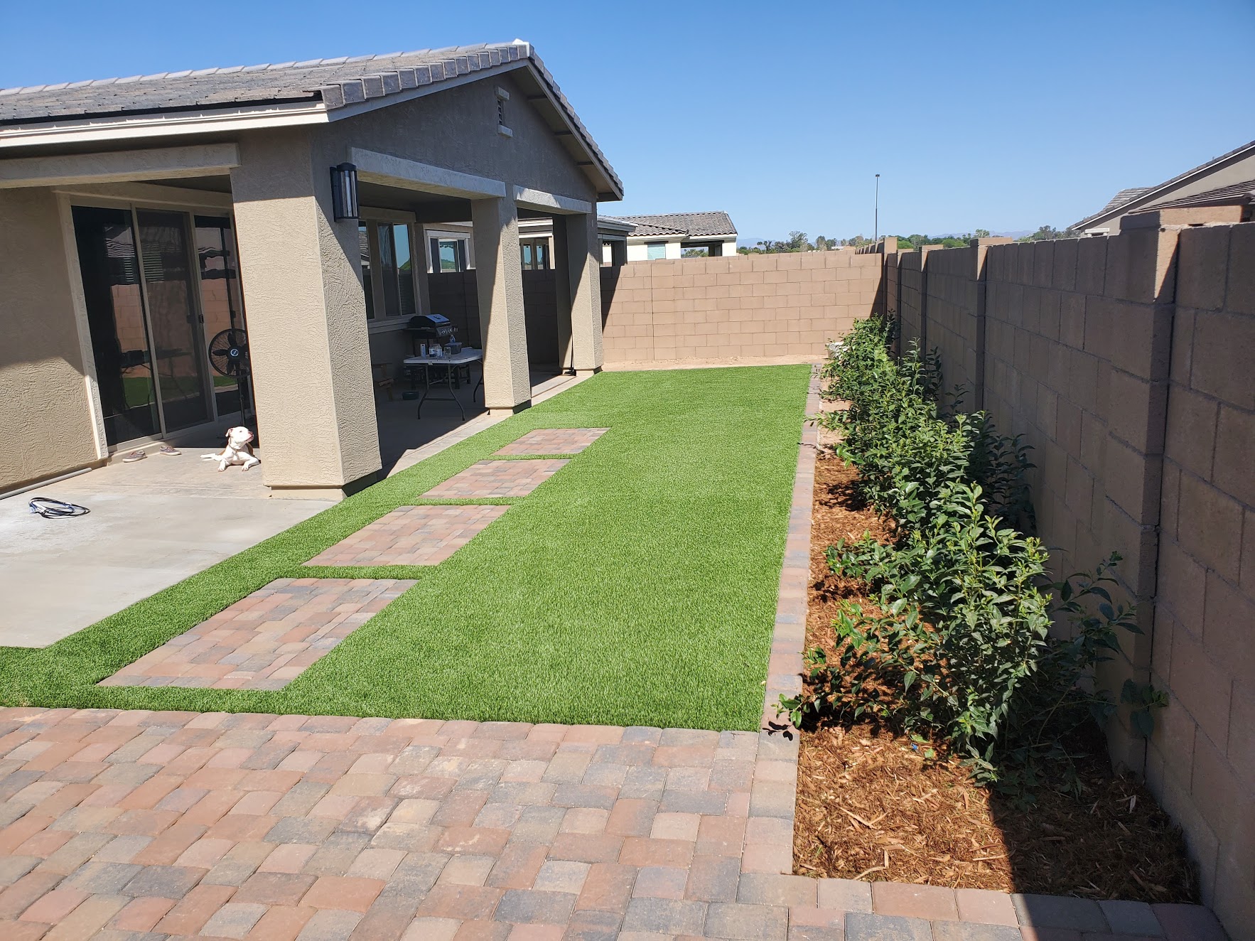 Photo of backyard work with paver steps and artificial turf